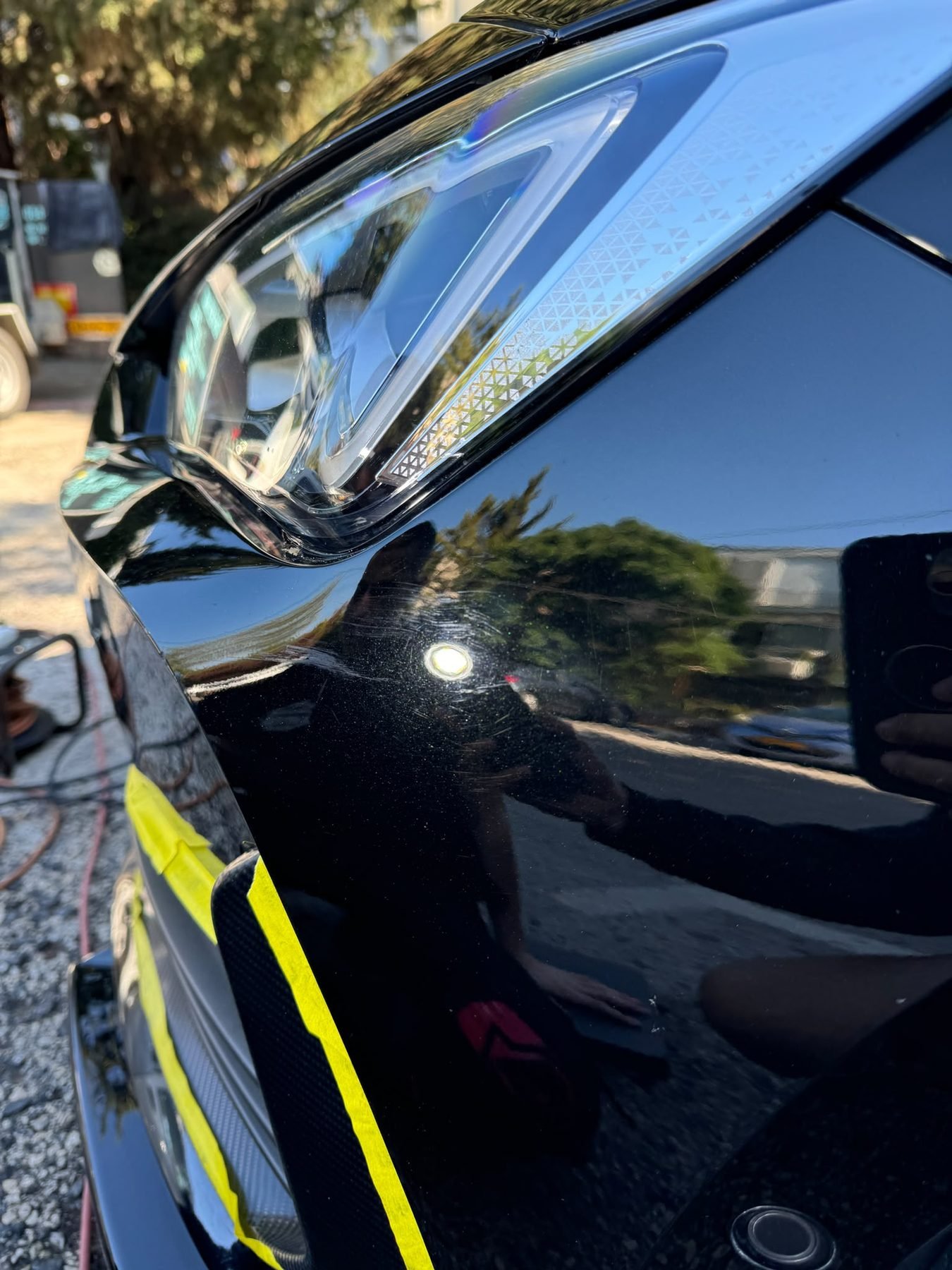 שריטות בצבע ליד הפנס עם מיסוך צהוב לפני פוליש