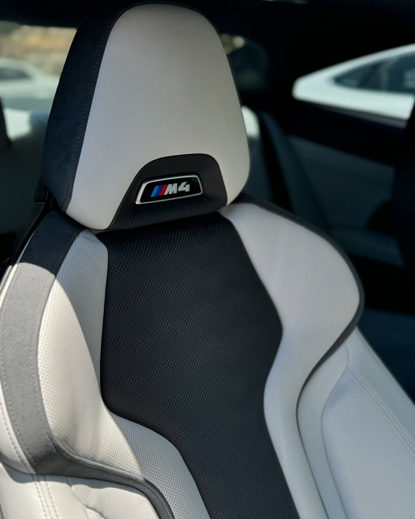 מושב ספורט של BMW M4 מעור לבן ושחור עם סמל M4 במשענת