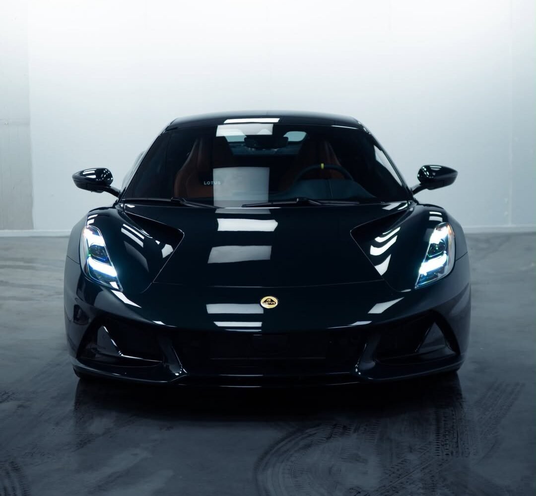 Lotus Emira שחורה מבט מלפנים, הצבע השחור משקף את תאורת הסטודיו